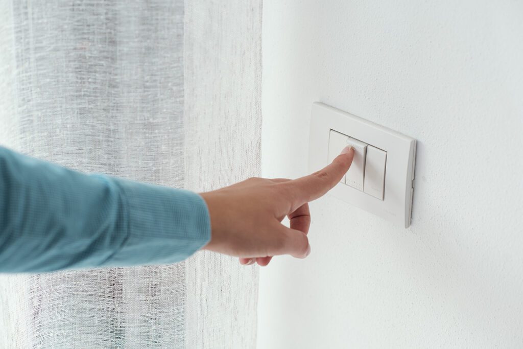 Customer turning on a standard slim light switch